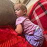 Leilani joined the competition — help win amazing prizes! toddler, sleeping, child, couch, blanket, red, plaid, pink_shirt, purple_skirt, indoors, cozy, resting, face, hair, soft_lighting, relaxation, furniture, home, comfort, peaceful