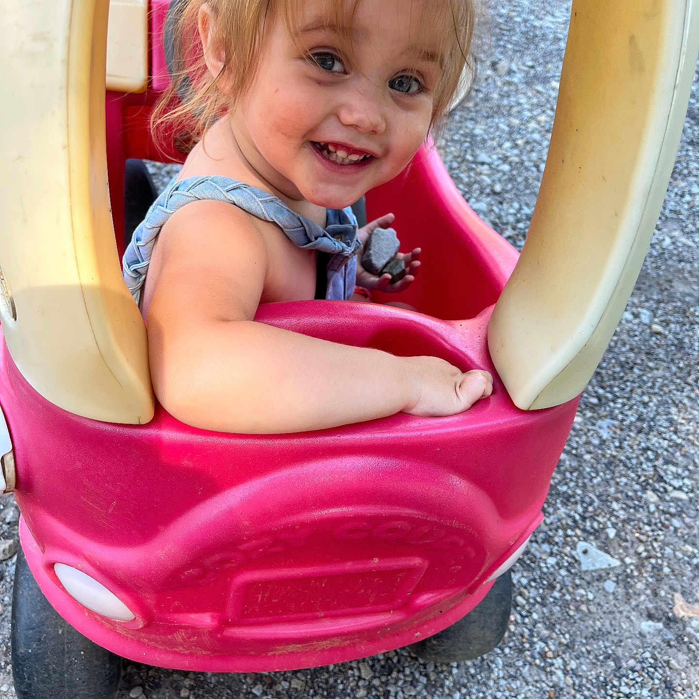 Leilani joined the competition — help win amazing prizes! toddler, child, smiling, toy_car, outdoor, gravel, play, happy, small_rock, casual_clothing, sunlight, cute, person, playtime, fun, daylight, plastic_toy, vehicle, young_child, portrait