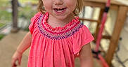 Leilani joined the competition — help win amazing prizes! child, toddler, girl, pink_dress, blue_eyes, pigtails, smiling, messy_face, outdoor, porch, wooden_railing, casual_clothing, playful, happy, person, young_child, daylight, standing, fun, cute