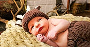 Neyland joined the competition — help win amazing prizes! baby, infant, knitted_hat, antlers, blanket, brown_pants, cozy, cute, lying_down, soft_texture, curious, indoors, portrait, warm_colors, headwear, newborn, child, resting, closeup, expression