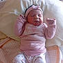 baby, newborn, infant, pink_clothing, headband, sleeping, pillow, blanket, bed, cute, peaceful, small_hands, lying_down, indoors, soft_lighting, heart_patterns, cozy, child, person, toddler