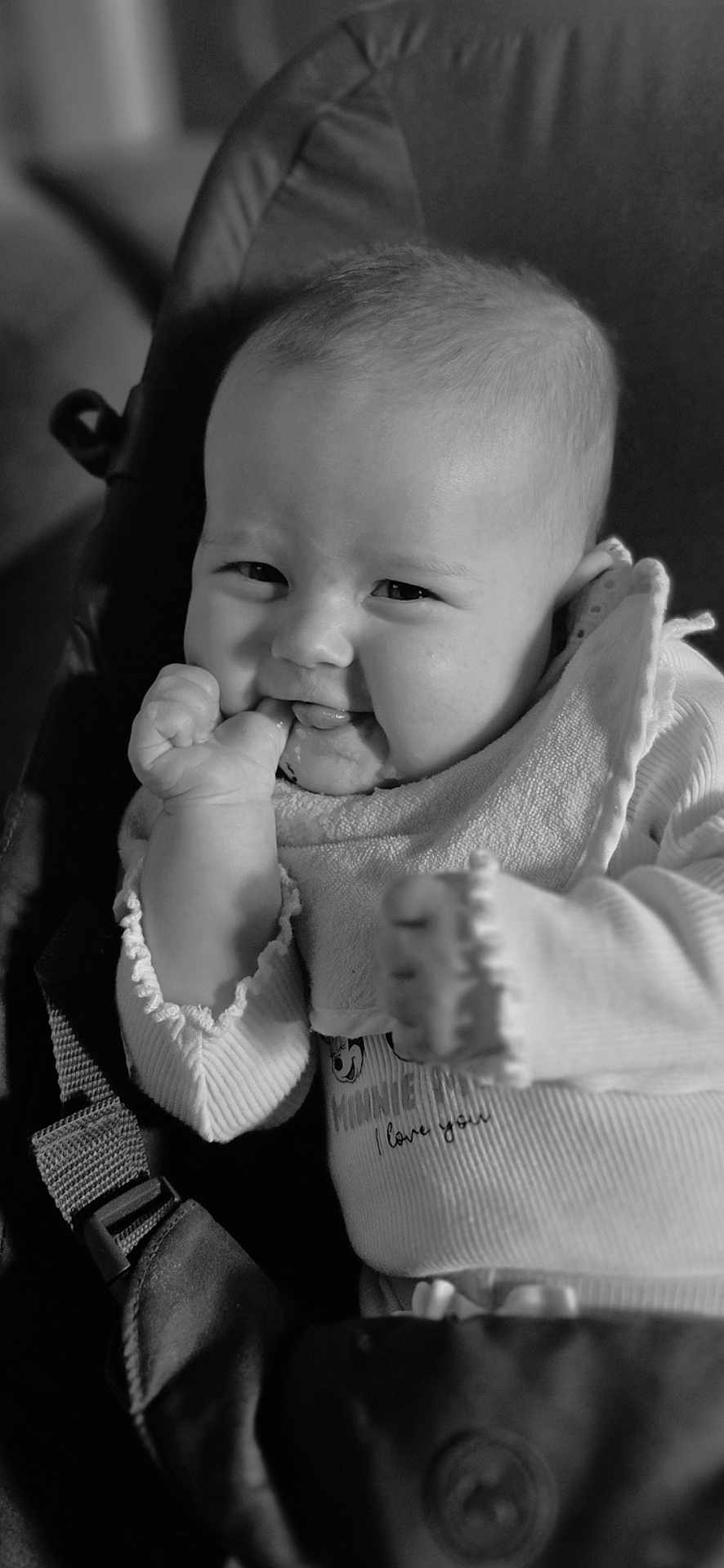 Octavia participe au concours pour gagner de l'argent avec cette photo : baby, infant, smiling, cheeks, hand, bib, clothing, seat, straps, black_and_white, portrait, cute, young_child, expression, cozy, indoor, soft_lighting, face, person, closeup