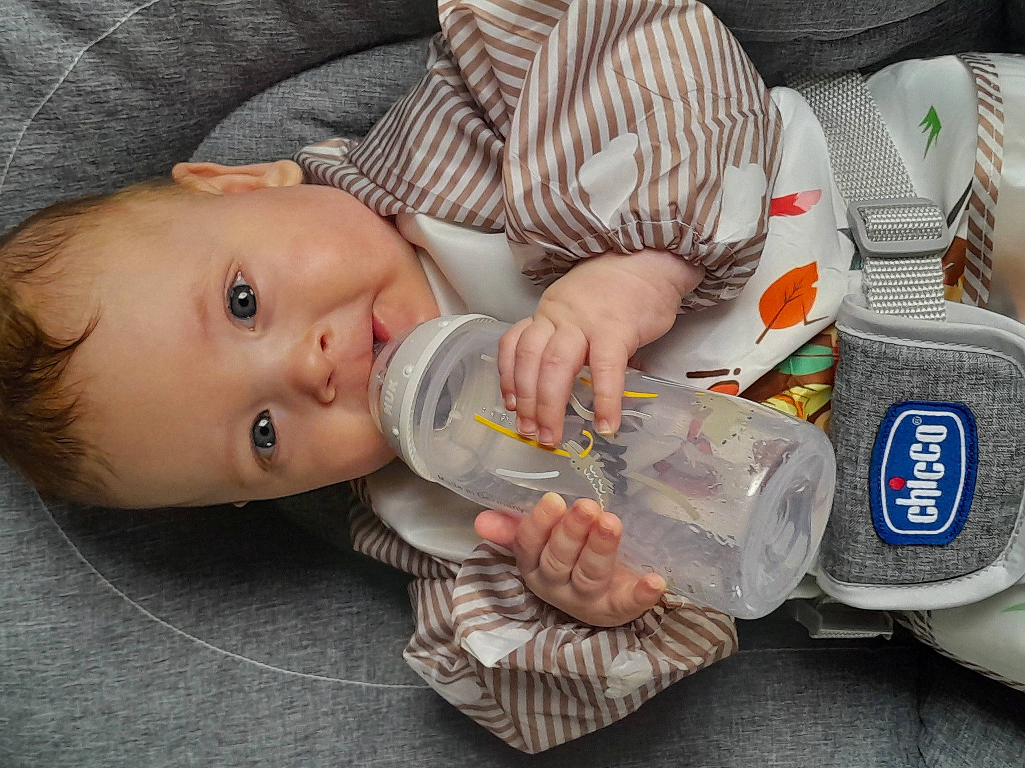 Liroy a rejoint le concours — aidez-le/la à gagner de superbes lots ! baby, baby_food, baby_products, baby_toddler_clothing, bottle, cheek, child, comfort, drinking, drinkware, finger, food, hand, human_body, mouth, nail, person, plastic_bottle, sitting, toddler