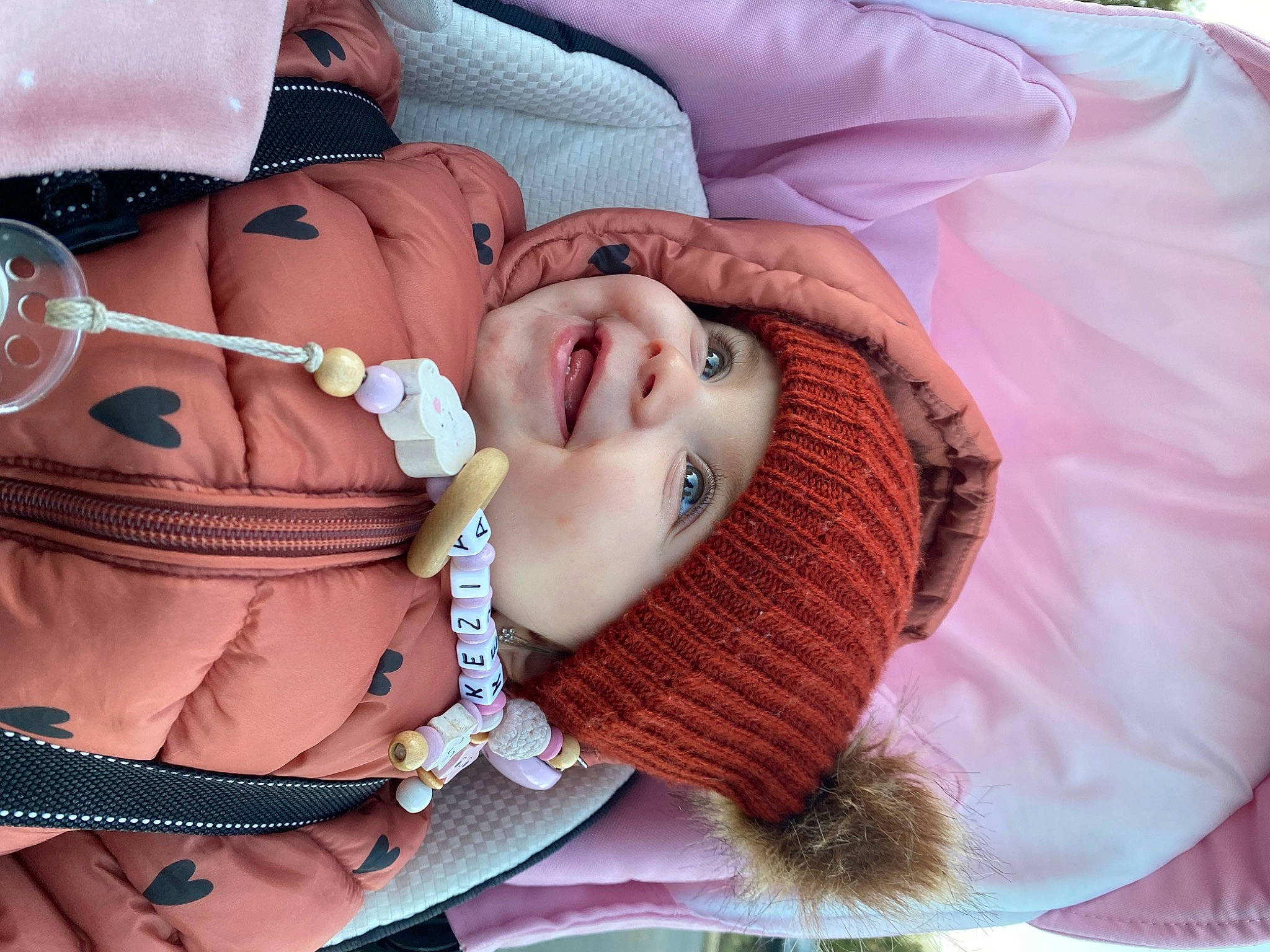 Kezia a rejoint le concours — aidez-le/la à gagner de superbes lots ! baby, baby_toddler_clothing, comfort, eye, eyelash, eyewear, face, happy, head, headgear, headwear, joy, lip, mouth, neck, people, person, pink, skin, sleeve