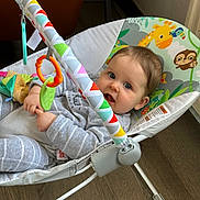 Victoria participe au concours pour gagner de l'argent avec cette photo : animal_prints, baby, baby_rocker, blue_eyes, child, clothing, colorful, comfort, cute, face, flooring, hands, happy, indoor, infant, person, playtime, seat, smile, toys