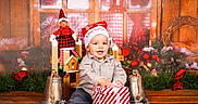 Noé participe au concours pour gagner de l'argent avec cette photo : baby, bells, child, christmas, decorations, elf_doll, festive_decor, gift_box, holiday, indoor, pinecone, portrait, present, santa_hat, sitting, smiling, toddler, toy, wooden_floor, wreath