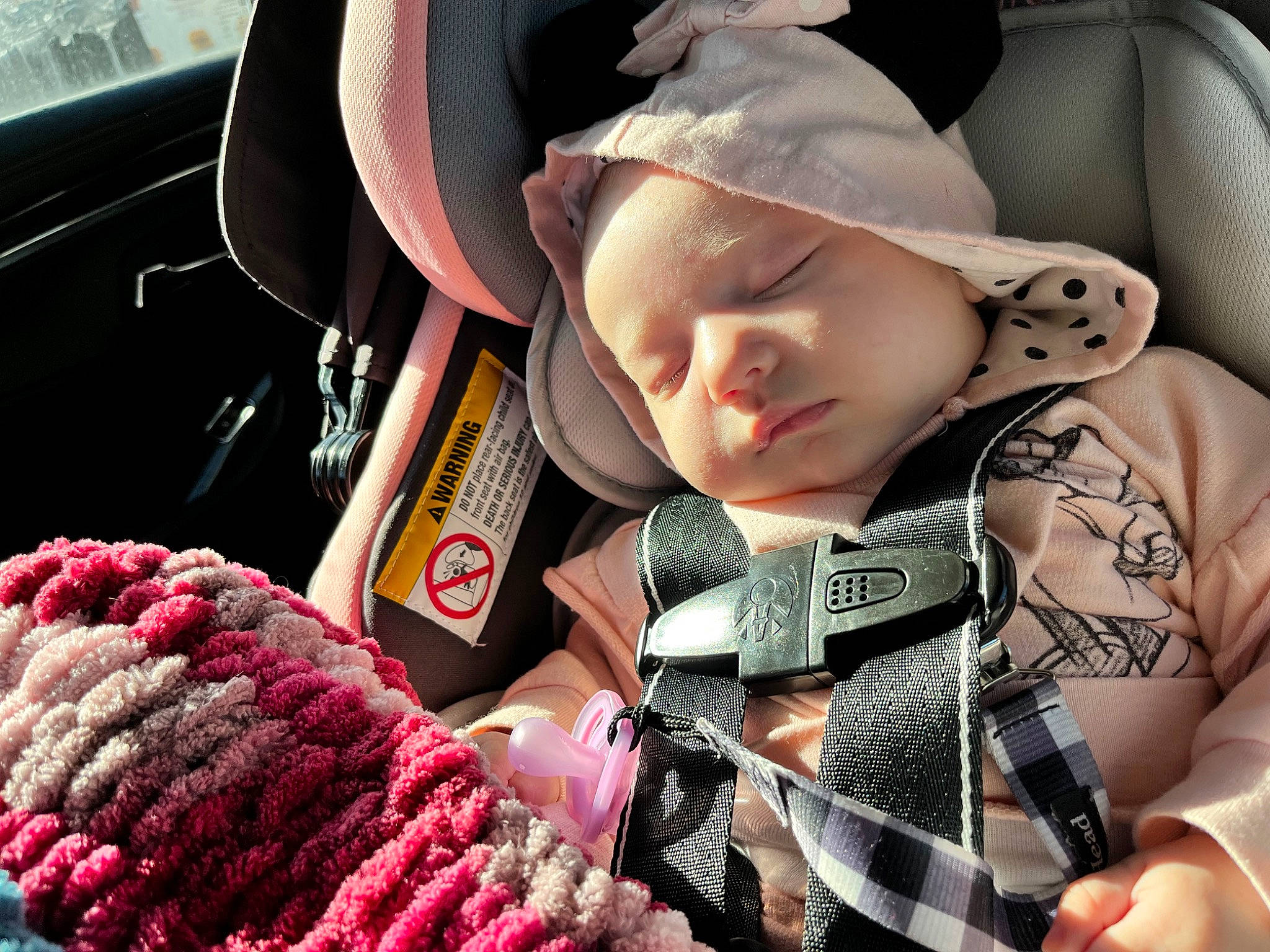 Adrianne is registered to the contest to win money with this photo: auto_part, baby, baby_carriage, cap, car_seat, car_seat_cover, comfort, eyelash, finger, hat, headgear, motor_vehicle, nail, pattern, person, pink, seat_belt, steering_wheel, textile, toddler
