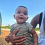 Liam joined the competition — help win amazing prizes! baby, child, person, outdoor, playground, swing, sky, greenery, hand, smile, happy, casual_clothing, adult, holding, daylight, nature, short_hair, cute, infant, expression