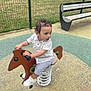 Caméo a rejoint le concours — aidez-le/la à gagner de superbes lots ! child, toddler, playground, spring_horse, outdoor, bench, fence, grass, curly_hair, white_shoes, shorts, shirt, play_area, daylight, park, spring, toy, person, recreation, fun