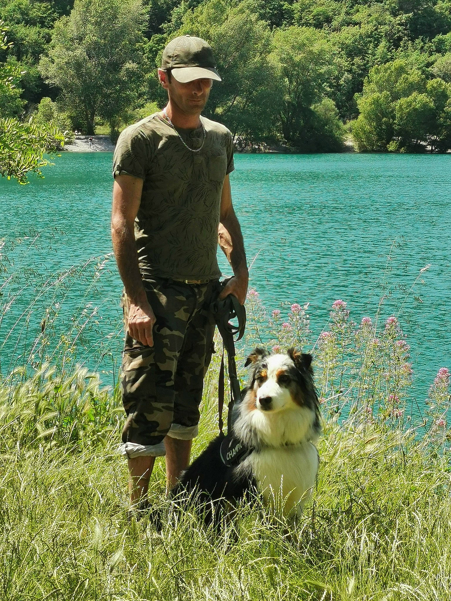 Moogli participe au concours pour gagner de l'argent avec cette photo : baseball_cap, cap, carnivore, companion_dog, dog, dog_breed, fedora, grass, green, hat, herding_dog, lake, luggage_and_bags, people_in_nature, plant, recreation, shorts, sun_hat, tree, water