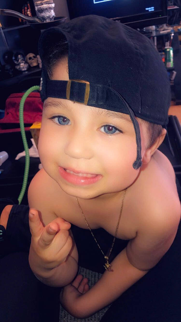 Armani is registered to the contest to win money with this photo: black_hair, cheek, child, chin, ear, eyebrow, face, forehead, fun, head, headgear, lip, neck, nose, person, skin, smile, thumb, toddler