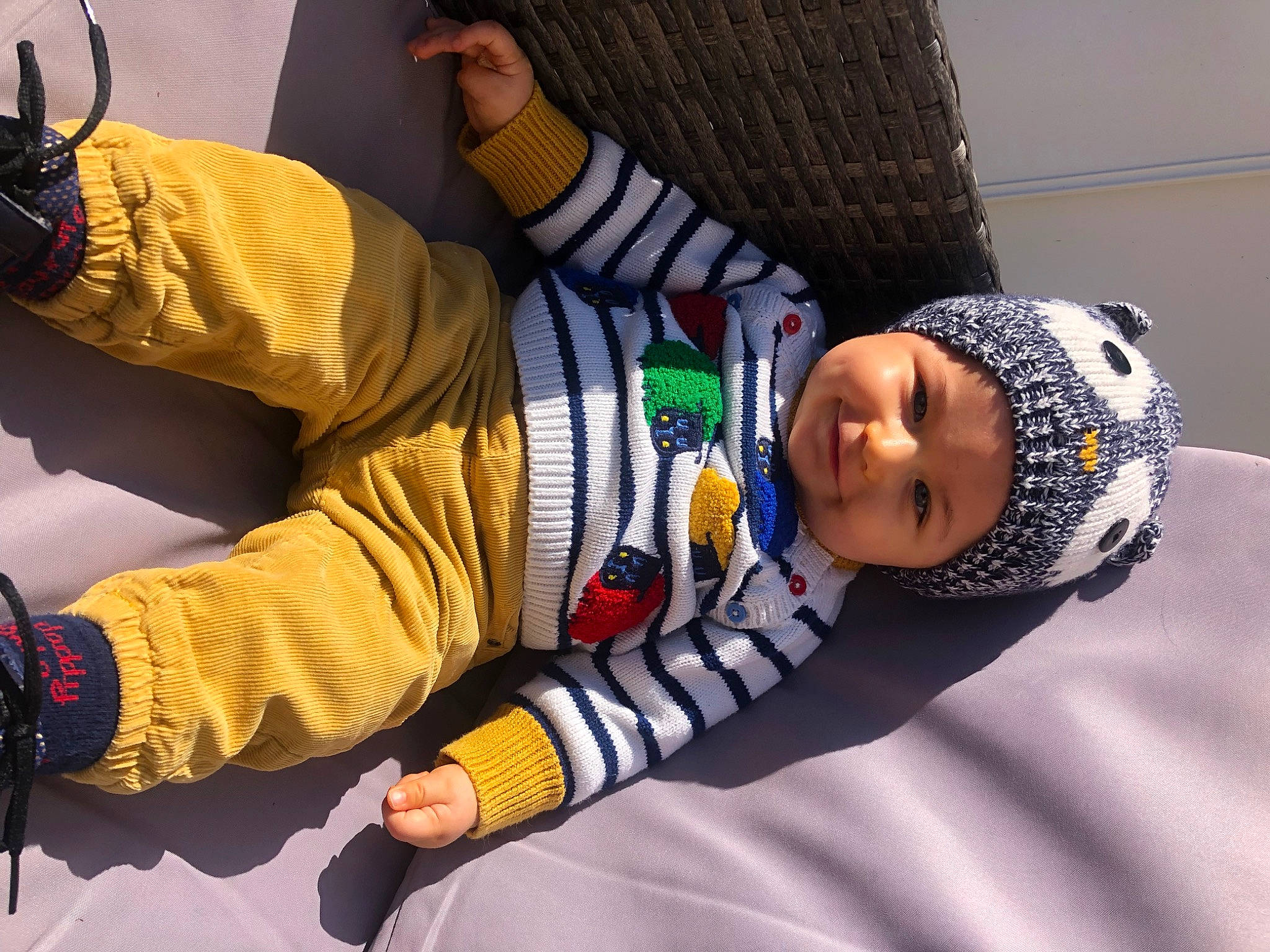 Livio a rejoint le concours — aidez-le/la à gagner de superbes lots ! baby, baby_toddler_clothing, beanie, cap, child, comfort, cool, elbow, flooring, hand, headgear, headwear, human_body, knee, outerwear, person, personal_protective_equipment, room, sitting, sleeve