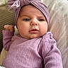 Elley participe au concours pour gagner de l'argent avec cette photo : baby, bedding, cheeks, close_up, clothing, cute, expression, eyes, face, gaze, headband, indoor, infant, lavender, onesie, pillow, pink, portrait, skin, soft_texture