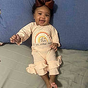 Cimani joined the competition — help win amazing prizes! baby, infant, smiling, bow, clothing, pillow, bed, blanket, cute, happy, person, child, indoors, apparel, newborn, lying_down, portrait, face, skin, expression