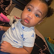 Cimani joined the competition — help win amazing prizes! toddler, child, baby, bed, bedroom, blue_eyes, bow, hair, clothing, pattern, toy, pillow, headboard, sitting, portrait, curious, indoor, person, young_child, cute