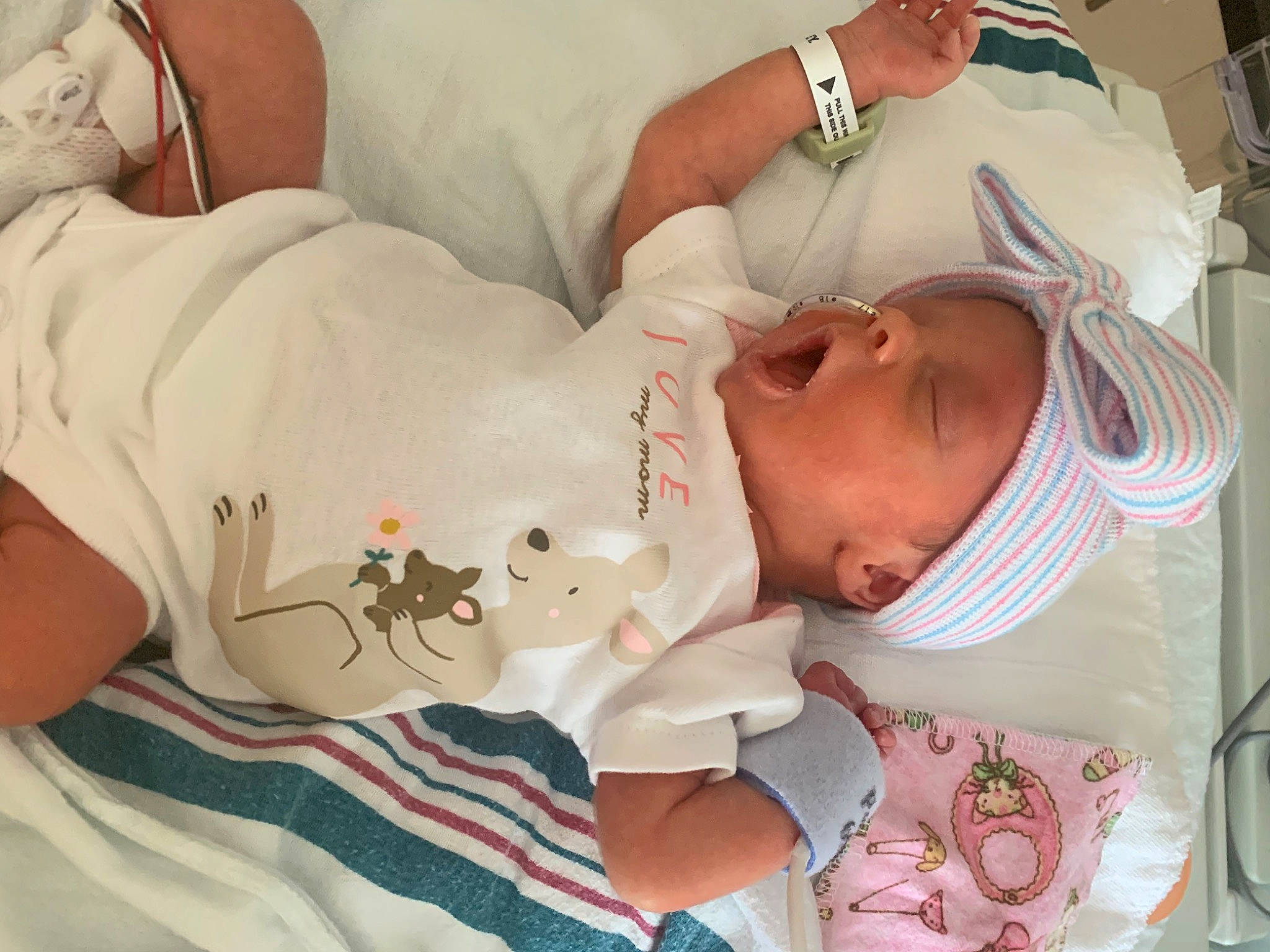 Katie is registered to the contest to win money with this photo: arm, baby, baby_products, baby_safety, baby_sleeping, baby_toddler_clothing, cheek, child, comfort, facial_expression, finger, hand, hospital_bed, linens, mammal, mouth, person, product, skin, toddler