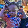 Jaxsin joined the competition — help win amazing prizes! animal_ears, background, blue_shirt, child, curious, face, hand, headwear, holding, indoor, lighting, orange_shirt, people, person, playful, shirt, sign, toddler, toy, wooden_wall