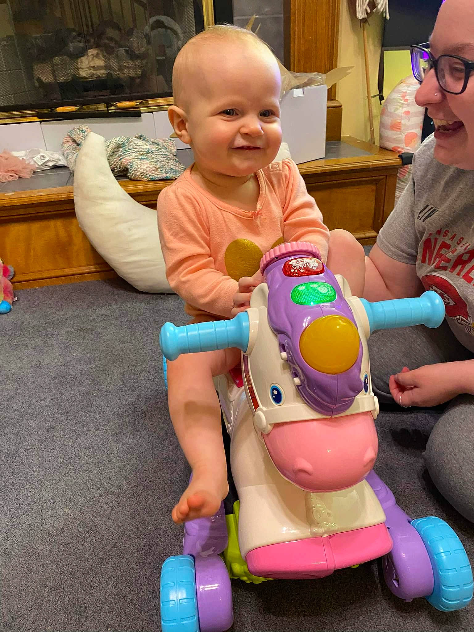 Mae joined the competition — help win amazing prizes! baby, child, event, facial_expression, fun, happy, head, joy, lap, leisure, organ, person, picture_frame, recreation, riding_toy, sitting, skin, smile, television, toddler