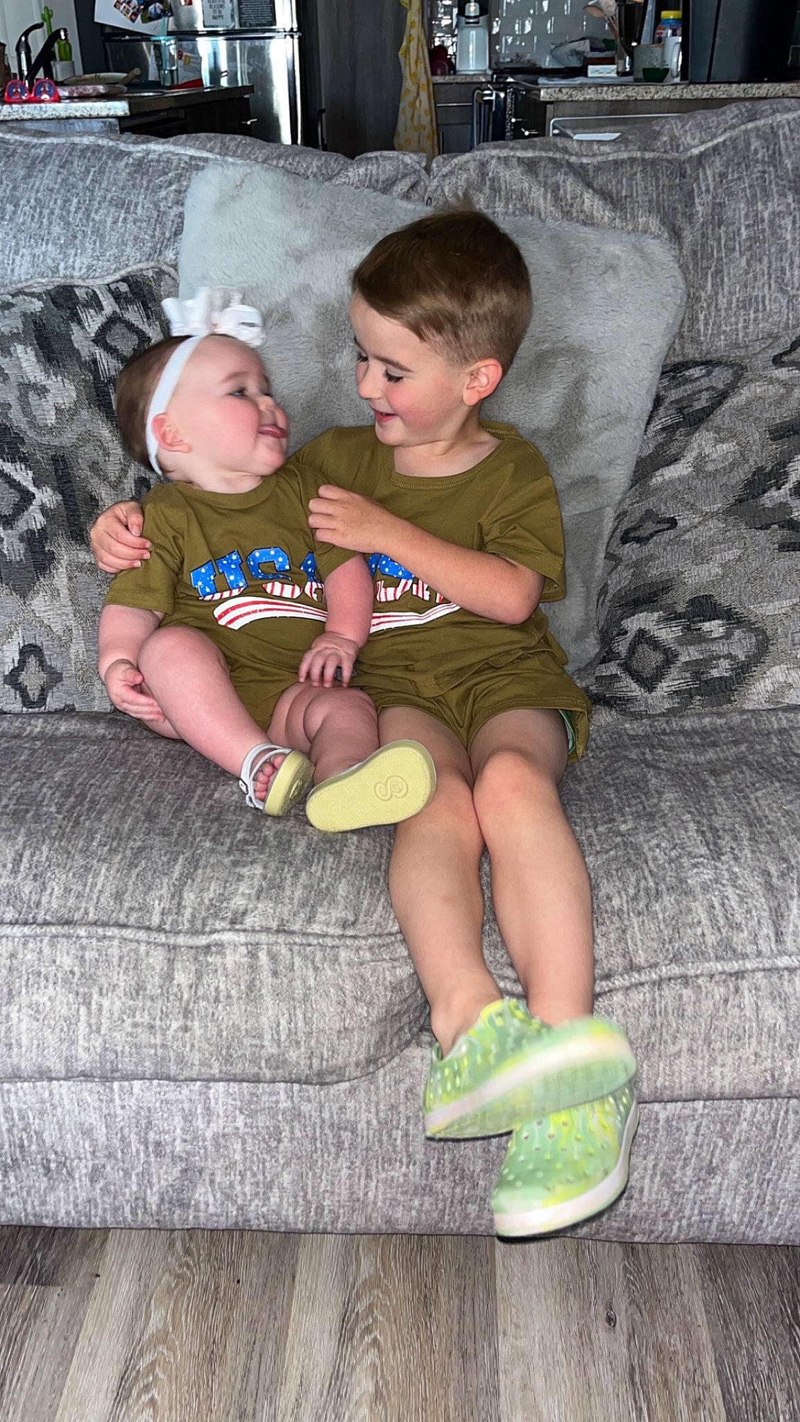 Ila is registered to the contest to win money with this photo: baby_toddler_clothing, child, comfort, event, face, flash_photography, fun, grass, happy, head, lap, leg, person, sitting, skin, sock, standing, t_shirt, thigh, toddler