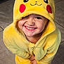 Leo a rejoint le concours — aidez-le/la à gagner de superbes lots ! child, toddler, smiling, yellow_onesie, pikachu_costume, cute, indoor, tile_floor, hooded_clothing, happy, portrait, playful, person, young_child, costume, bright, fun, expression, casual, footwear
