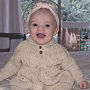 June participe au concours pour gagner de l'argent avec cette photo : baby, child, smiling, knitwear, headband, indoor, bed, happy, portrait, clothing, toddler, cute, infant, sitting, cozy, warm, face, person, room, window