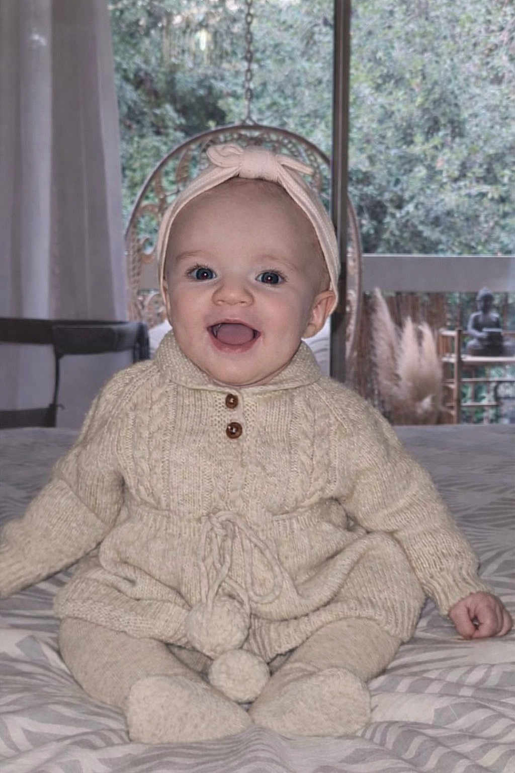 June participe au concours pour gagner de l'argent avec cette photo : baby, child, smiling, knitwear, headband, indoor, bed, happy, portrait, clothing, toddler, cute, infant, sitting, cozy, warm, face, person, room, window