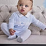 toddler, child, baby, blue_outfit, couch, tufted_furniture, curly_hair, studio_equipment, indoor, portrait, sitting, clothing, expression, cute, person, photography, face, hand, footwear, background