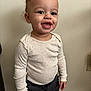 Mase is registered to the contest to win money with this photo: toddler, child, smiling, standing, curly_hair, long_sleeve_shirt, pants, indoor, carpet, wall, happy, cute, portrait, person, young_child, small_hands, light_skin, casual_clothing, real_photo, innocent