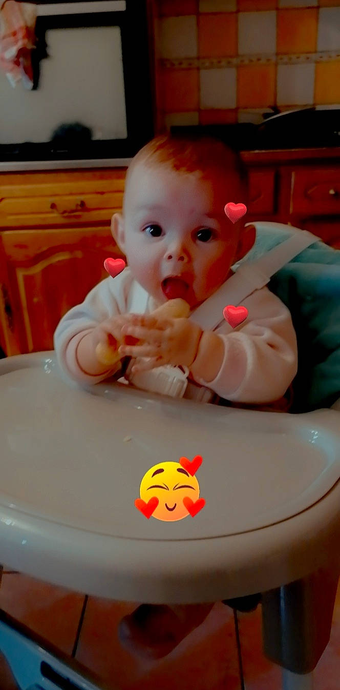 Ezia participe au concours pour gagner de l'argent avec cette photo : baby, baby_food, baby_playing_with_toys, baby_products, baby_safety, baby_toddler_clothing, bib, cabinetry, chair, cheek, chest_of_drawers, child, comfort_food, drawer, face, fun, head, person, sitting, surprise