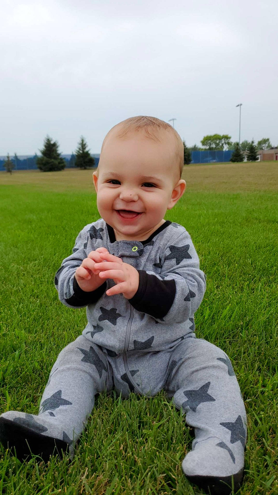 Maddox joined the competition — help win amazing prizes! baby, baby_toddler_clothing, field, fun, grass, grassland, happy, joy, lawn, meadow, people_in_nature, person, plant, prairie, sitting, skin, sky, sleeve, smile, spring