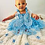 Ambre participe au concours pour gagner de l'argent avec cette photo : baby, bed, bedroom, blanket, bodypart, clothing, dress, face, finger, furniture, happy, head, indoors, person, photography, portrait, quilt, room, sitting, smile