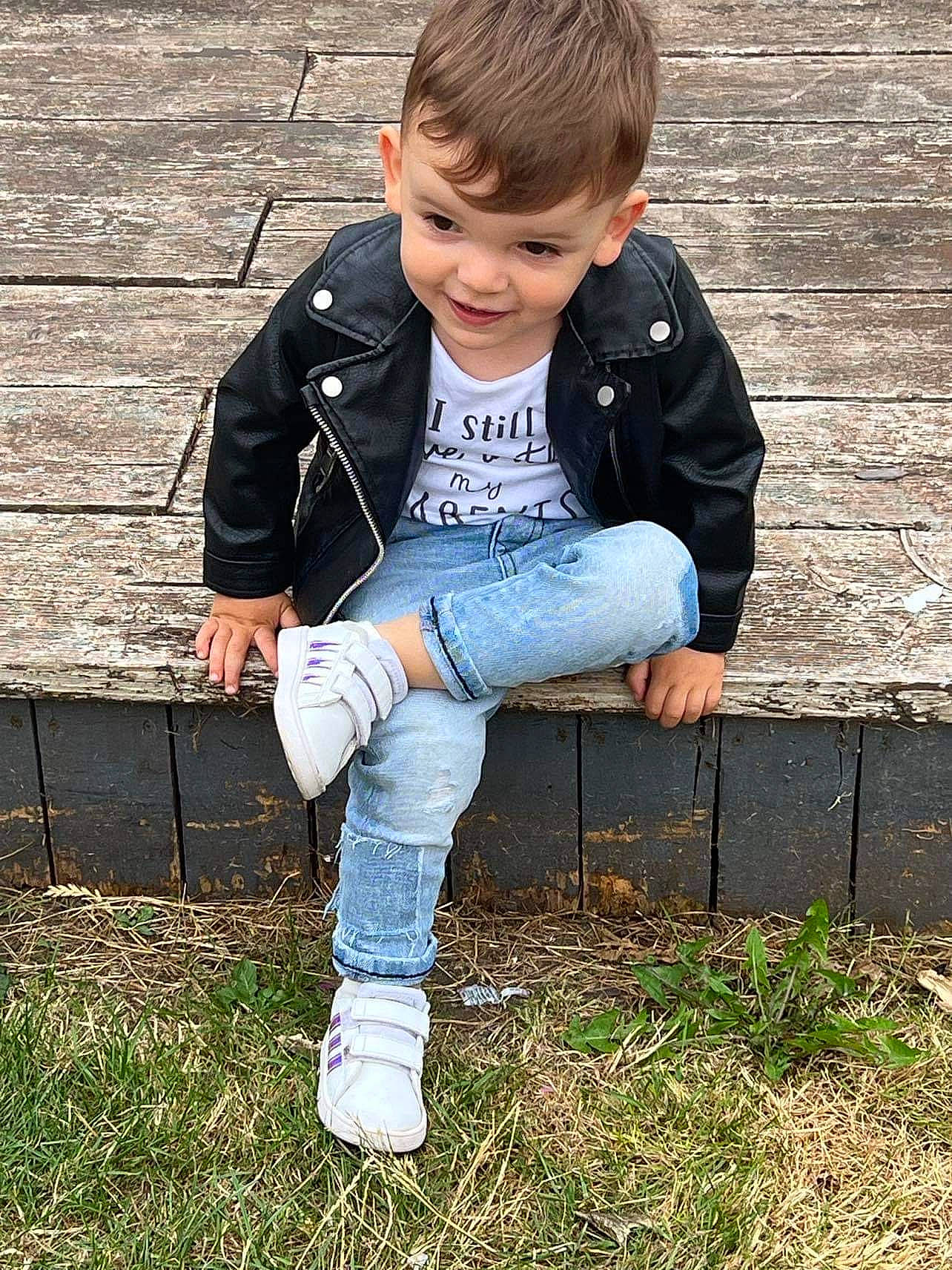 Matthias is registered to the contest to win money with this photo: bangs, child, denim, electric_blue, eye, face, formal_wear, fur, grass, happy, head, joy, pattern, people_in_nature, person, sitting, sleeve, soil, t_shirt, toddler