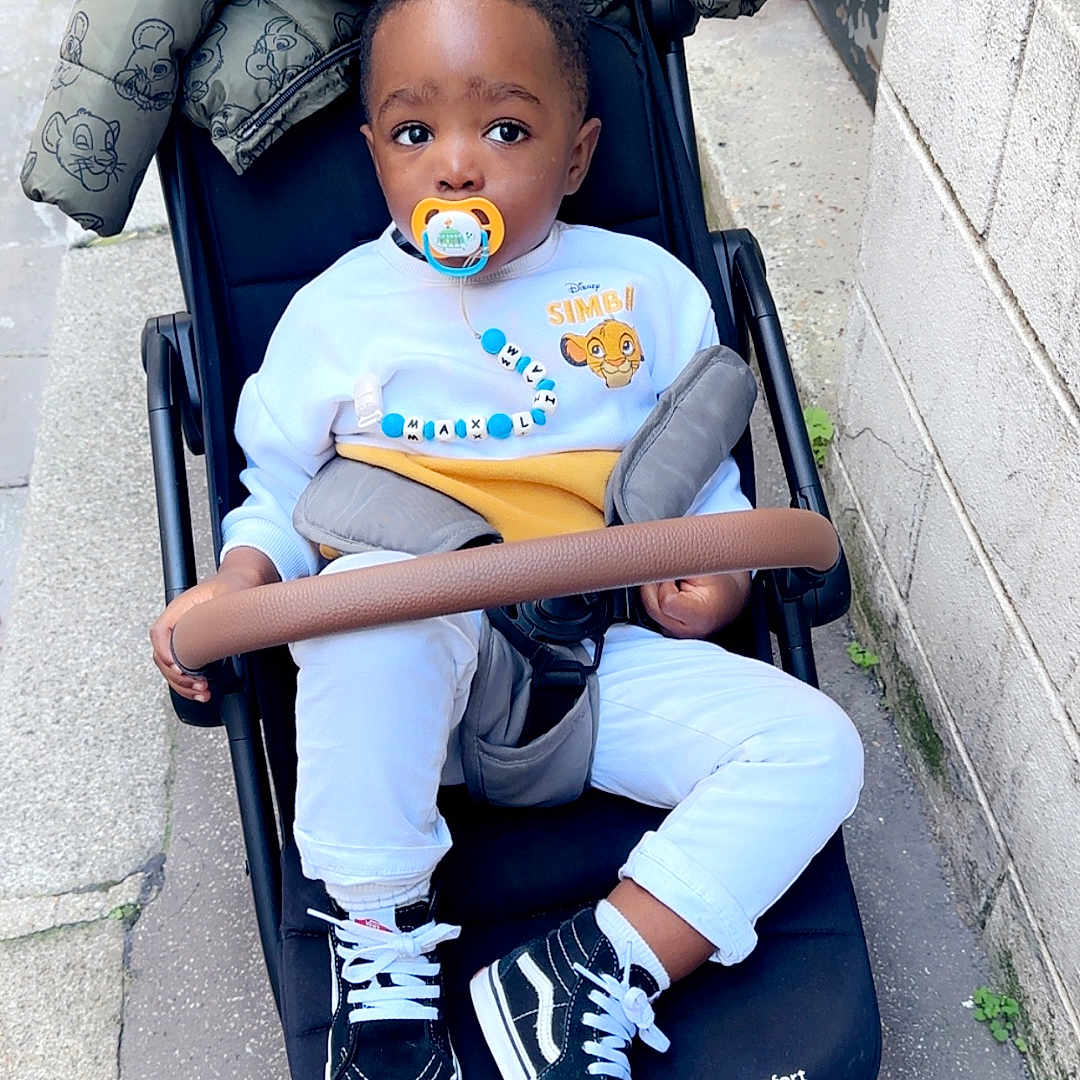 Liam Hugo participe au concours pour gagner de l'argent avec cette photo : baby, child, clothing, curious, daytime, disney, jacket, outdoor, pacifier, pants, person, shoes, sidewalk, simba, sneakers, street, stroller, sweatshirt, toddler, urban