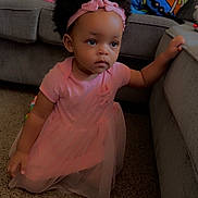 Milani joined the competition — help win amazing prizes! toddler, child, pink_dress, headband, carpet, couch, sofa, indoor, baby, kneeling, furniture, toy, spongebob, pillow, curly_hair, person, young_child, living_room, home, cute