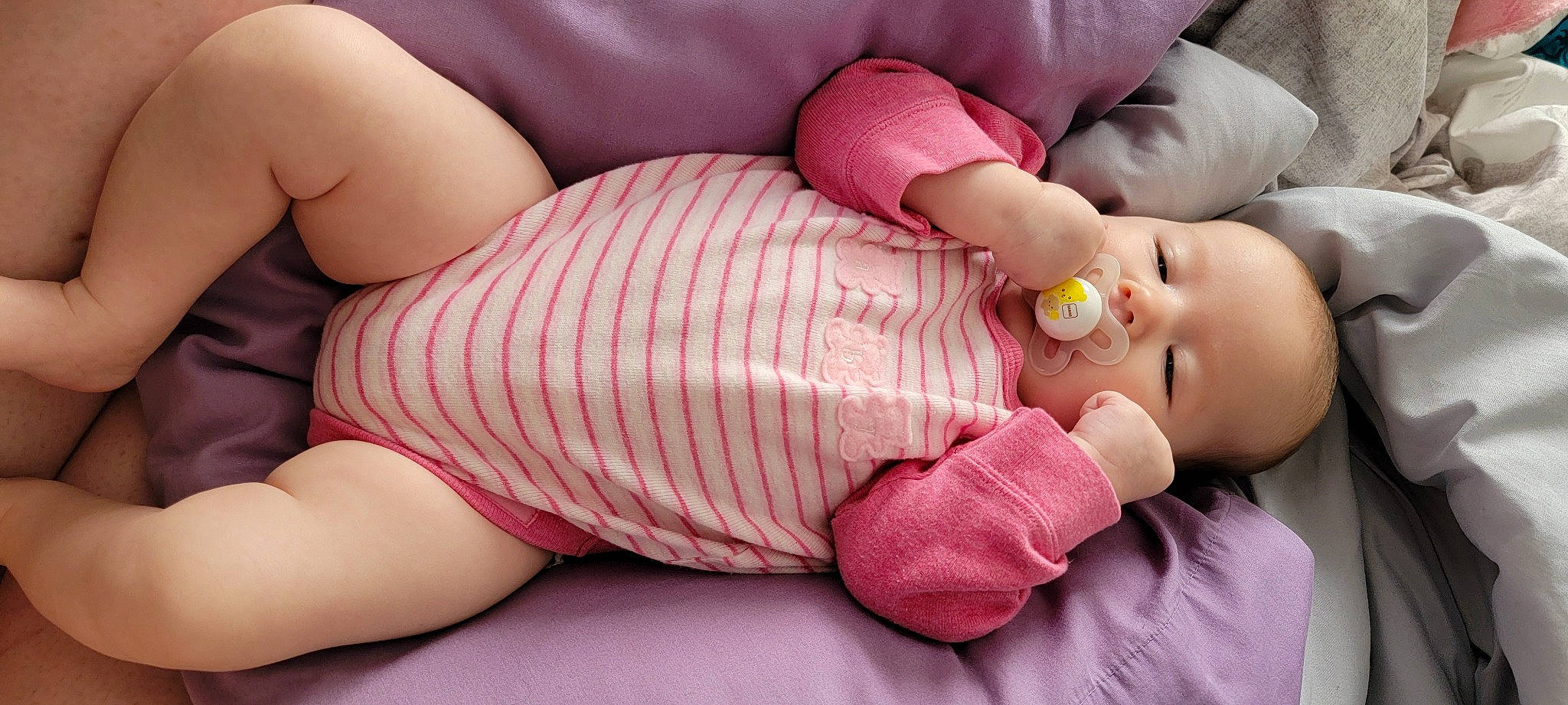 Freya is registered to the contest to win money with this photo: baby, baby_sleeping, baby_toddler_clothing, cheek, comfort, finger, hand, human_body, human_leg, knee, lip, mouth, nail, person, pink, skin, stomach, textile, thigh, thumb