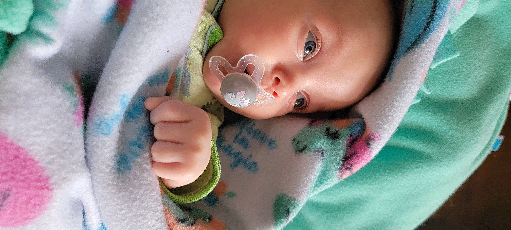 Ezra is registered to the contest to win money with this photo: arm, baby, baby_toddler_clothing, cheek, dishware, drinkware, eye, eyebrow, eyelash, finger, gesture, hand, happy, lip, mouth, nail, neck, nose, person, skin