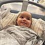 Lou a rejoint le concours — aidez-le/la à gagner de superbes lots ! baby, smiling, blanket, pillow, bassinet, indoor, face, child, comfort, happy, striped, pattern, tiled_wall, head, person, infant, wrapped, cozy, soft, resting