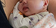 Amelia is registered to the contest to win money with this photo: baby, sleeping, blanket, onesie, infant, closeup, face, peaceful, cozy, person, tattoo, skin, resting, cute, soft, comfort, child, arm, adult, indoor