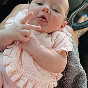 Arbour Grace joined the competition — help win amazing prizes! baby, infant, pink_clothing, blanket, car_interior, steering_wheel, dashboard, hand_gesture, tongue_out, person, feet, toenail_paint, tattoo, comfort, cute, closeup, portrait, skin, expression, lap