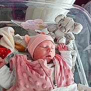 Ayana participe au concours pour gagner de l'argent avec cette photo : newborn, baby, sleeping, pink_clothing, hat, blanket, plush_toy, koala, hospital_bassinet, infant, child, soft_toys, sleep, person, cute, indoors, bed, rest, newborn_care, cozy