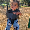 Chance is registered to the contest to win money with this photo: child, toddler, smiling, playground, swing, outdoor, park, portrait, curly_hair, happy, sitting, playground_equipment, safety_bar, mickey_mouse, pants, shoes, trees, wood_chips, sunlight, daytime