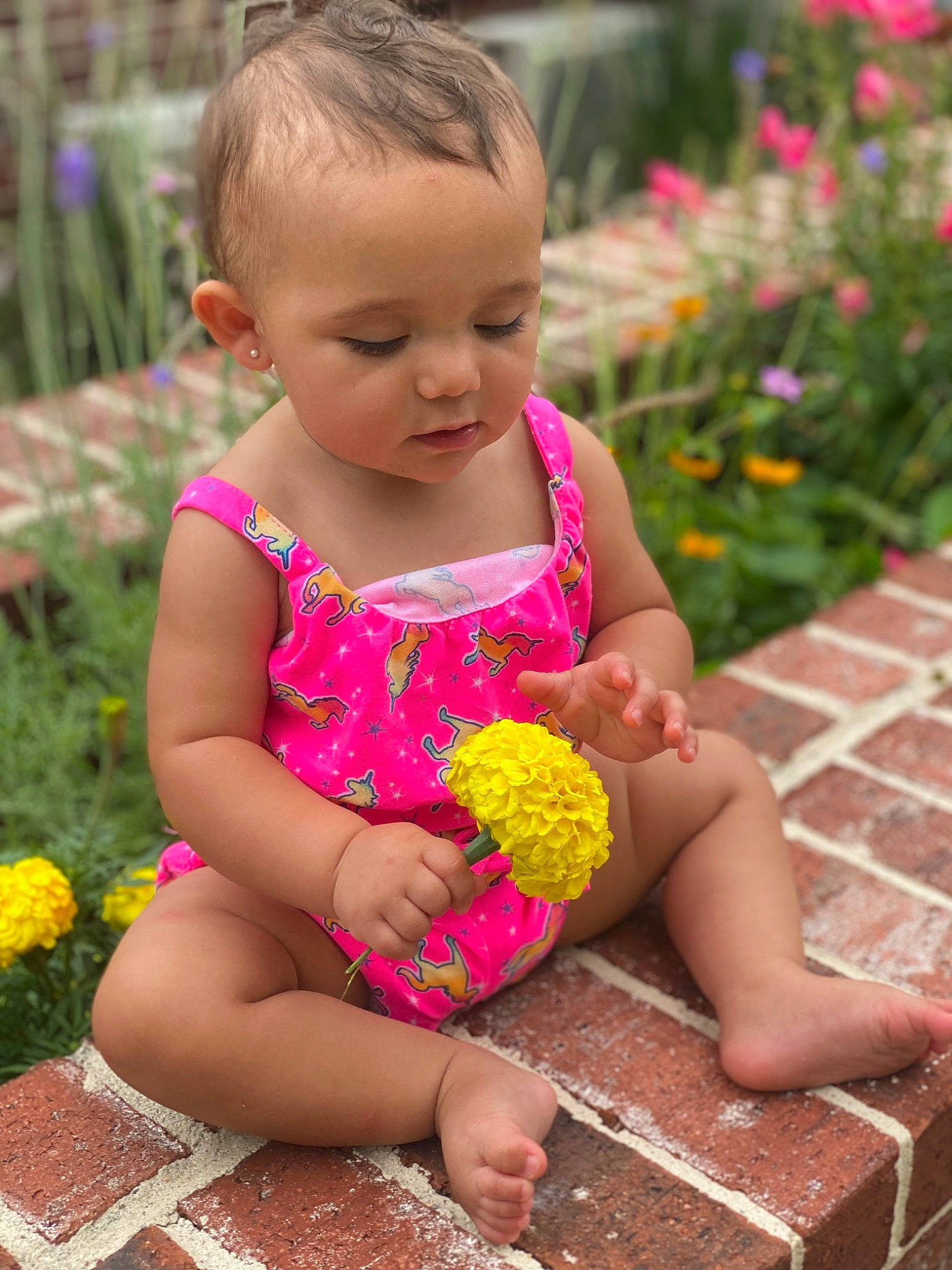 Princess is registered to the contest to win money with this photo: baby_toddler_clothing, botany, face, finger, flower, grass, hair, hairstyle, hand, happy, head, leaf, leg, nature, people_in_nature, person, petal, photograph, pink, plant