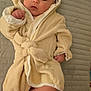 Lukas is registered to the contest to win money with this photo: baby, infant, robe, hood, blanket, bed, foot, hand, face, skin, person, indoor, cute, soft, sleepwear, child, newborn, portrait, lying, comfort