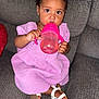 Zalaya is registered to the contest to win money with this photo: child, couch, cute, drinking, expression, face, footwear, gray, hair_clips, hand, indoors, lilac_dress, person, pink, portrait, sippy_cup, sitting, toddler, white_sandals, young_child