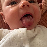 Phoebe is registered to the contest to win money with this photo: baby, blanket, child, close_up, clothing, cute, expression, face, head, indoor, infant, mouth, newborn, person, portrait, skin, soft, tongue, tongue_out, young