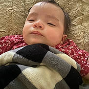 Lilian joined the competition — help win amazing prizes! baby, blanket, candid, child, closeup, comfort, cozy, face, hair, head, indoors, infant, lying_down, pattern, plaid, red_clothing, resting, sleepy, soft, texture