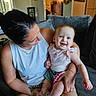 baby, child, woman, smile, happy, indoor, couch, blue_eyes, holding, casual_clothing, home, portrait, seated, parent, love, skin, furniture, tattoo, bracelet, shorts