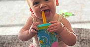 Hazel joined the competition — help win amazing prizes! baby, child, sippy_cup, smiling, sitting, indoors, playful, carpet, colorful, toy, happy, cute, infant, person, young_child, mouth, face, hand, legs, casual_clothing