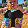 baby, child, swing, playground, outdoor, sunny, blue_sky, colorful_clothing, tongue_out, happy, infant, playtime, summer, daylight, park, toddler, fun, smiling, chain, seat