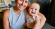 Hazel is registered to the contest to win money with this photo: arm, baby, casual, child, clothing, couch, decor, face, furniture, happy, home, indoor, living_room, person, portrait, seated, skin, smile, tattoo, woman